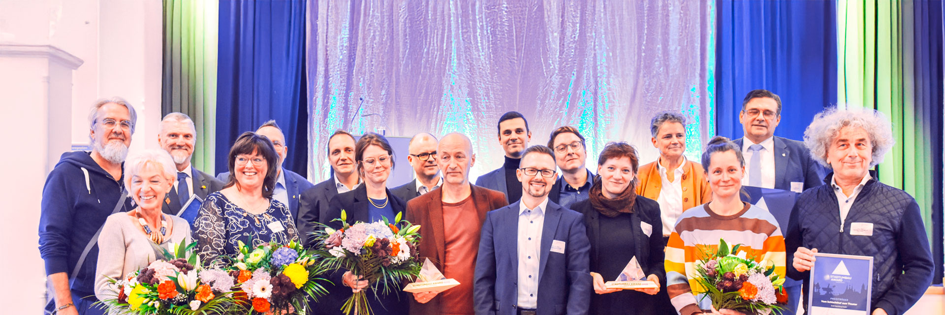 Die Preisträger des STADTUMBAU AWARDS 2025 auf der Bühne. Ein Gruppenfoto der Preisträger des STADTUMBAU AWARDS 2025 auf der Bühne.